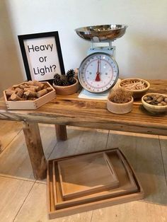 a wooden table topped with bowls filled with food next to a weight scale and sign