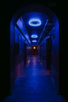 an empty hallway with blue lighting and dark walls