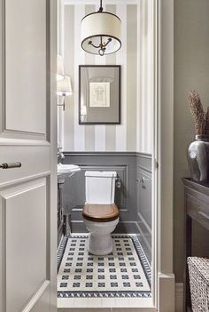 a bathroom with a toilet, sink and mirror on the wall next to an open door