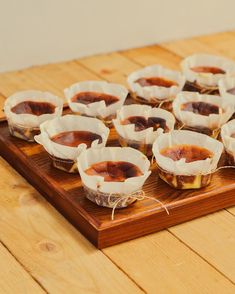 small desserts are sitting on a wooden tray ready to be eaten by someone else