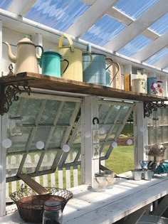 an old window is used as a shelf for pots and pans on the porch