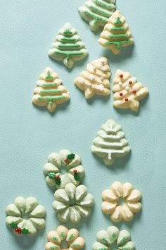 several decorated cookies sitting on top of a blue table next to green and white decorations