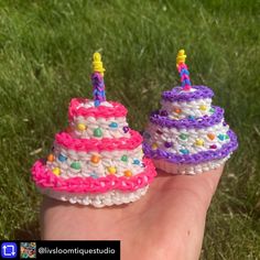 two small birthday cakes sitting on top of each other in someone's hand with grass behind them