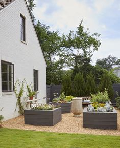 an outside view of a house with some plants in the front yard and on the ground