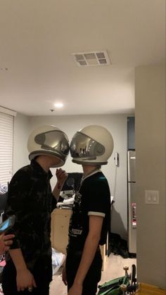 two people wearing helmets in a room