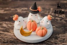 three small figurines sitting on top of a white plate