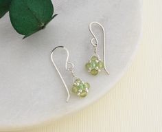 Our peridot earrings feature beautiful green gemstones dangling from handmade sterling silver ear wires, perfect for celebrating an August birthday or your 16th anniversary.  The dainty dangle sways gently as you move adding pop of color and sparkle that will accentuate any outfit.  A symbol of good cheer, the dainty earrings are a meaningful and timeless treat for your jewelry collection.  GEMSTONE SIGNIFICANCE *August birthstone *16th anniversary gemstone *Believed to bring good cheer and health to the wearer HANDMADE WITH LOVE: The cheerful gems are carefully selected, and hand woven into a diamond shape with small silver beads and a sparkling green crystal sits at the center.  The beaded drop is wire wrapped using sterling silver wire to matching handmade ear wires. READY TO GIFT: The Green Drop Earrings For Birthday, Peridot Drop Earrings For May Birthstone, Peridot Dangle Earrings Gift, Handmade Peridot Earrings As Gift, Dainty Green Sterling Silver Earrings, Green Sterling Silver Earrings For May Birthstone, Green Peridot Earrings For Anniversary, Lime Green Sterling Silver Earrings For Gift, Gift Lime Green Sterling Silver Earrings