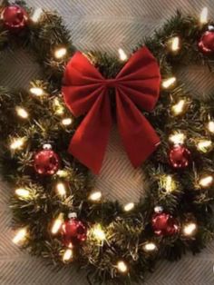 a christmas wreath with lights and a red bow