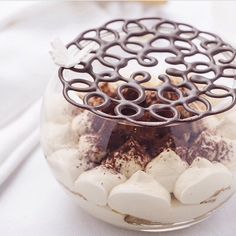 a glass jar filled with marshmallows and other things on top of a table