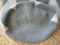 two crocheted baskets sitting on top of a wooden floor