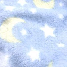 a teddy bear laying on top of a bed covered in a blue and yellow blanket