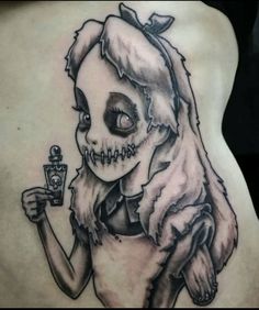 a woman with a tattoo on her back holding a bottle and wearing a skeleton mask