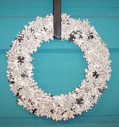 a paper wreath with black and white crosses on it hanging from a blue door frame