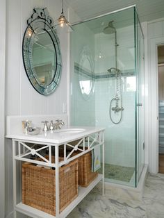 a bathroom with a sink, mirror and shower stall in the corner next to two wicker baskets