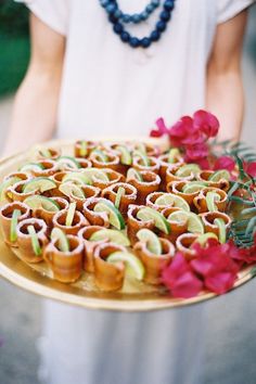 there is a plate with food on it and flowers in front of the platter