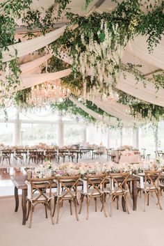 an instagram photo of a wedding venue with flowers and greenery hanging from the ceiling