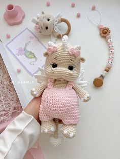 a small crocheted stuffed animal in a pink dress