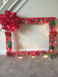 a red and green photo frame decorated with christmas lights, bows and candy canes