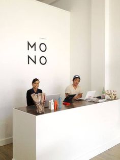 two people sitting at a desk in front of a sign that says moo no