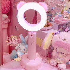 a pink teddy bear light up mirror next to other stuffed animals and toys in a room