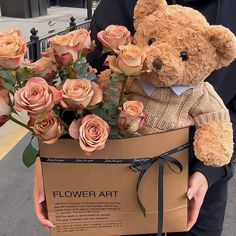 a person holding a teddy bear with flowers in it