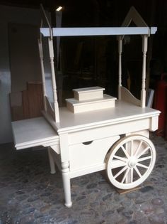 a small white cart sitting on top of a stone floor