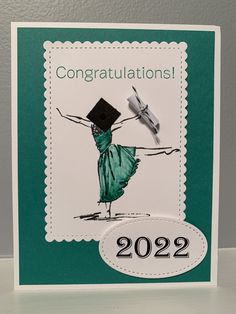 a congratulations card with a drawing of a woman in a green dress and graduation cap