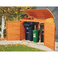 a wooden storage shed with trash cans in it