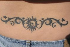 a woman's stomach with a sun and stars tattoo on her side ribcage