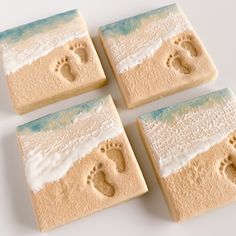 four pieces of soap with footprints in the sand