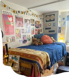 a bedroom with posters on the wall and a teddy bear sitting on top of it