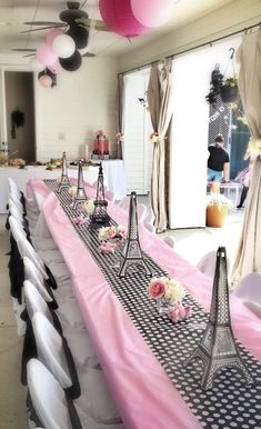 the table is set up with pink and black decorations for an eiffel tower themed party