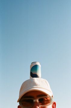 a man wearing sunglasses and a hat on top of his head with the sky in the background