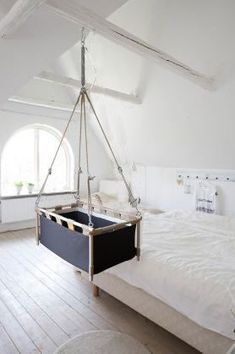 a bedroom with a hammock hanging from the ceiling and bed in front of it