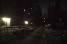 a dark street at night with snow on the ground