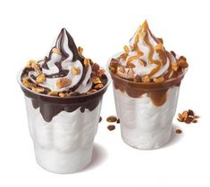 two ice cream sundaes with chocolate sauce and nuts