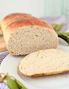 a loaf of bread sitting on top of a white plate next to a slice of bread