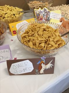 a table topped with bowls filled with cereal and other snacks on top of a white table cloth