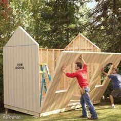 two men are building a shed in the yard