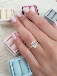 a close up of a person's hand with an engagement ring