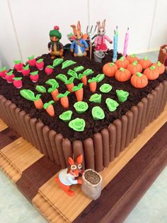 there is a cake with carrots and other decorations on the top it has chocolate icing