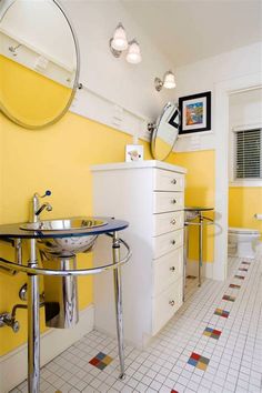 a bathroom with yellow walls and white tile on the floor is pictured in this image