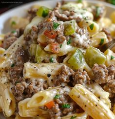 a close up of a plate of pasta with sausage and peppers on it, ready to be eaten