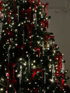 a decorated christmas tree with red bows and lights