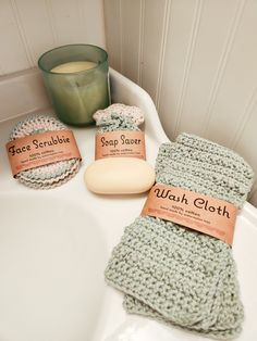 two soaps are sitting on the edge of a bathroom sink next to a green candle