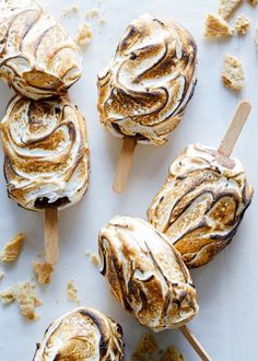 marshmallows are sitting on top of a sheet of parchment paper and have been drizzled with icing