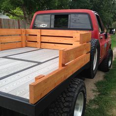 a red truck parked next to a wooden fence