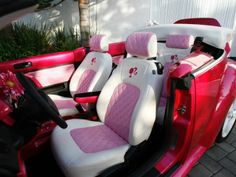 the interior of a car with pink and white seats