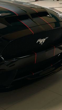 the front end of a black mustang with red stripes