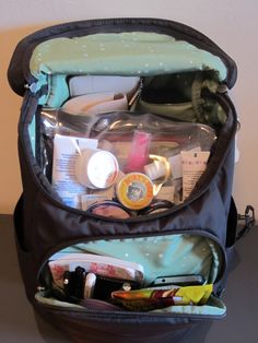 an open backpack filled with cosmetics and other personal care items on top of a table